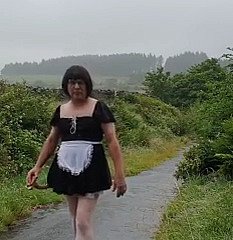 Transvestitenmädchen at hand einer öffentlichen Gasse im Regen